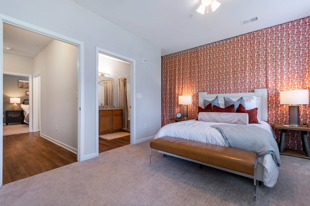 A bedroom with a large bed and a patterned wallpaper.