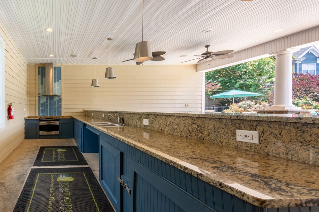 A kitchen with a long counter and a fire extinguisher on the wall.