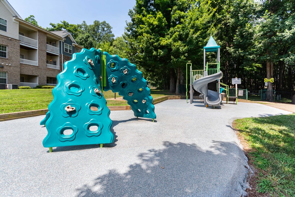 A playground with a blue slide and a green play structure.