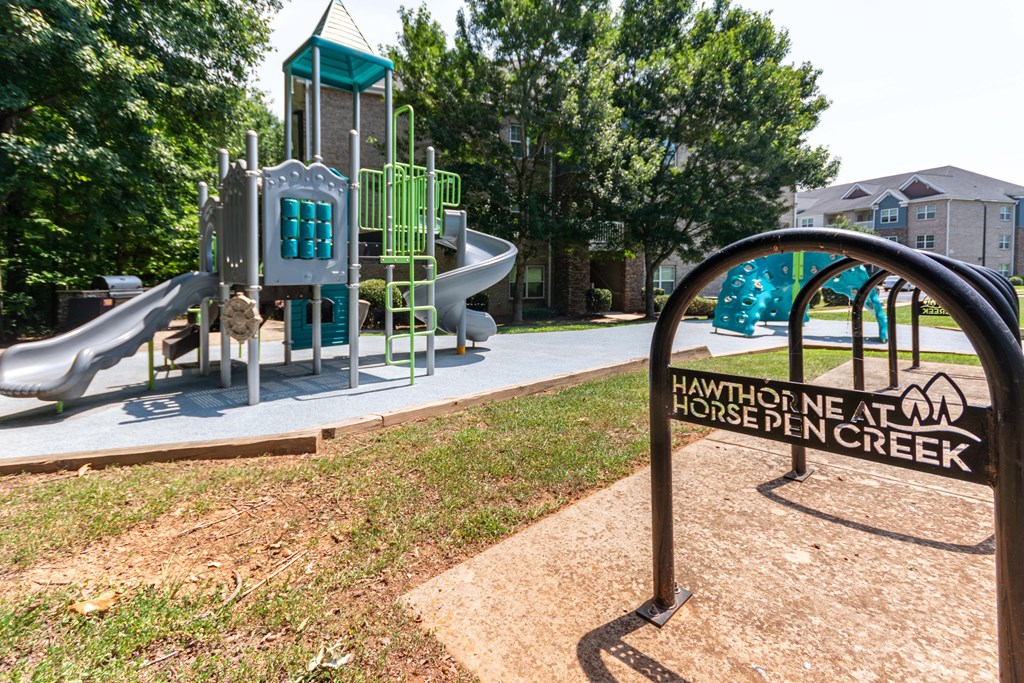 A playground with a slide and a sign that says Hawthorne Ne at Horse Pen Creek.
