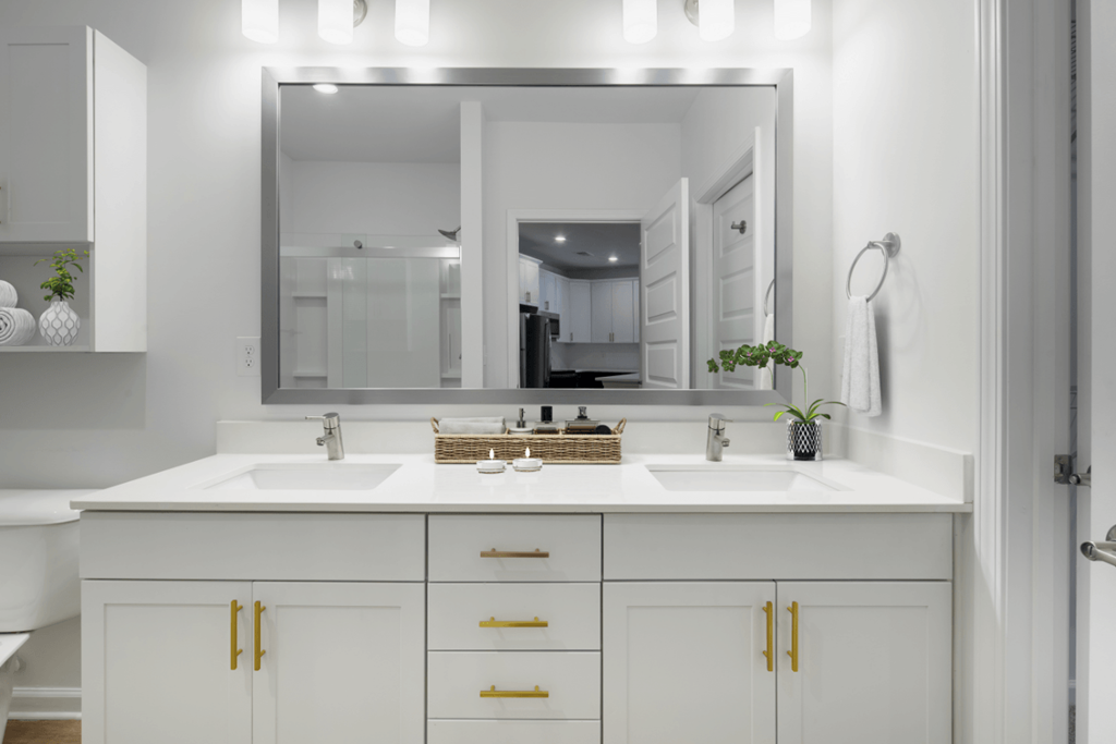 a white bathroom with two sinks and a large mirror