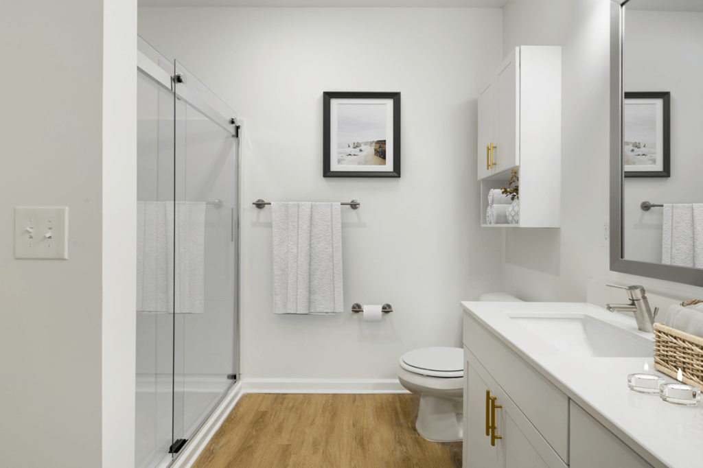 a bathroom with a glass shower and a sink and a toilet
