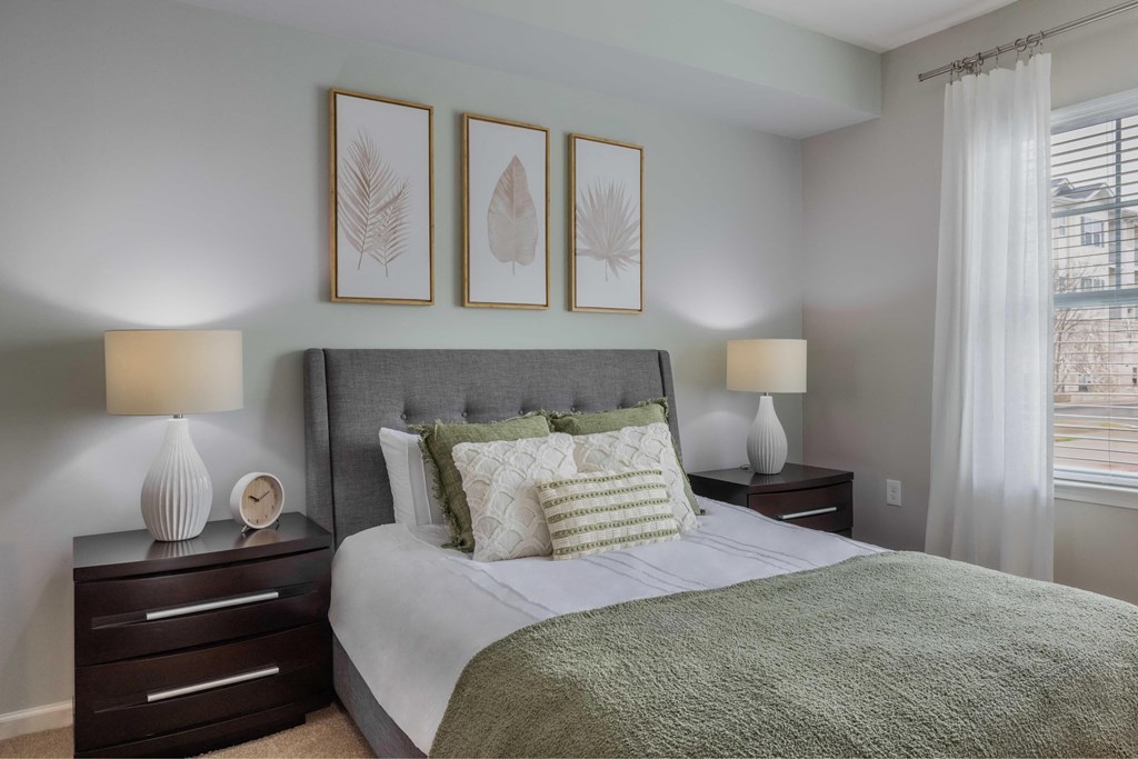 a bedroom with a bed and three pictures on the wall