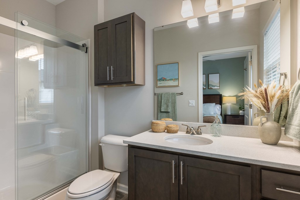 a bathroom with a shower sink and toilet and a mirror
