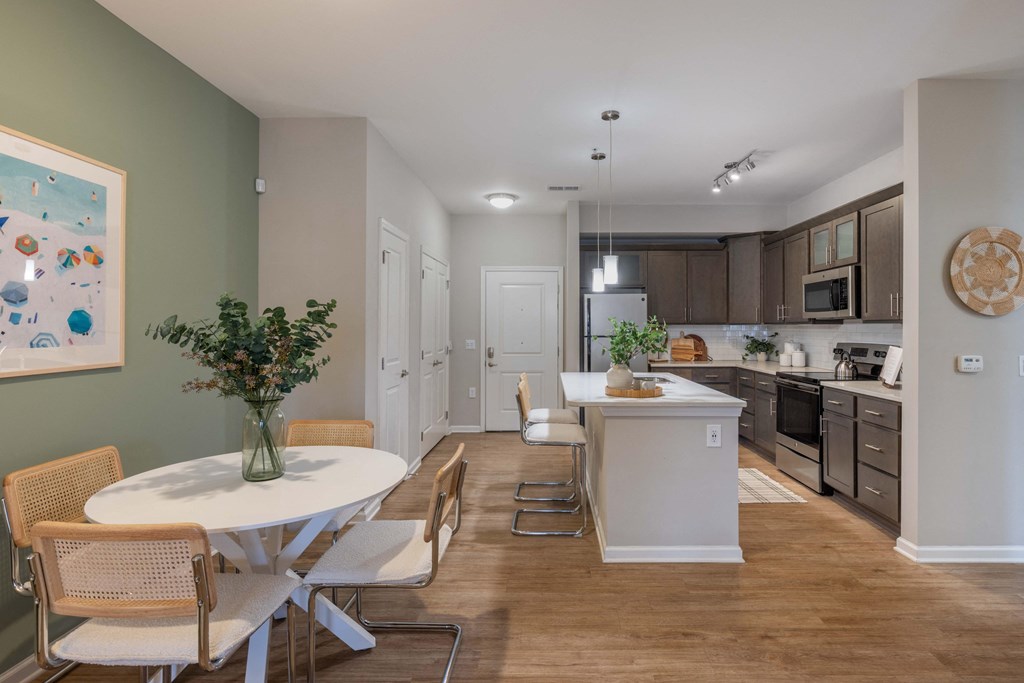 a dining room and kitchen with a white table and chairs
