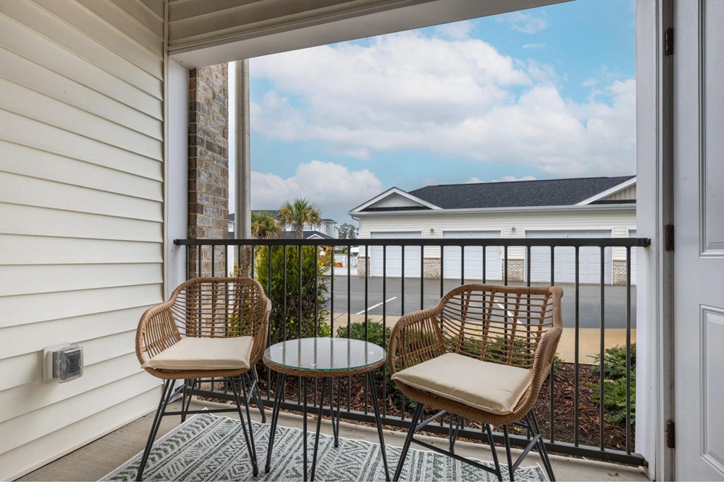 a patio with two chairs and a table on a balcony