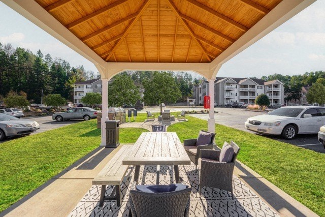 a picnic table and chairs under a pavilion at a parking lot