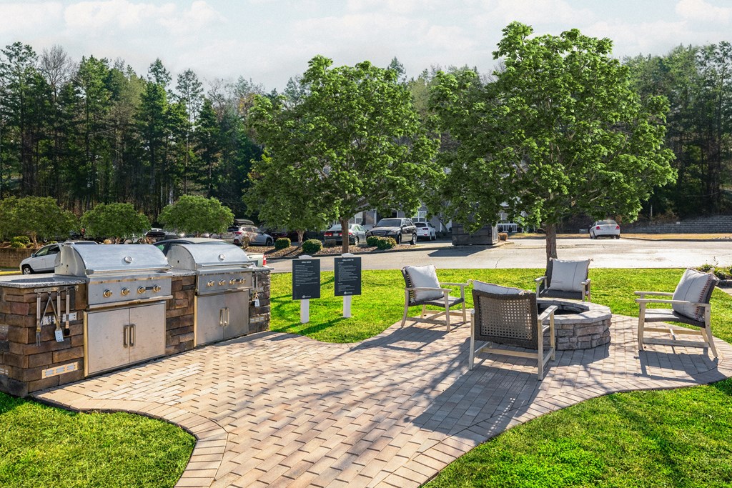 a patio with a grill and a picnic table and chairs