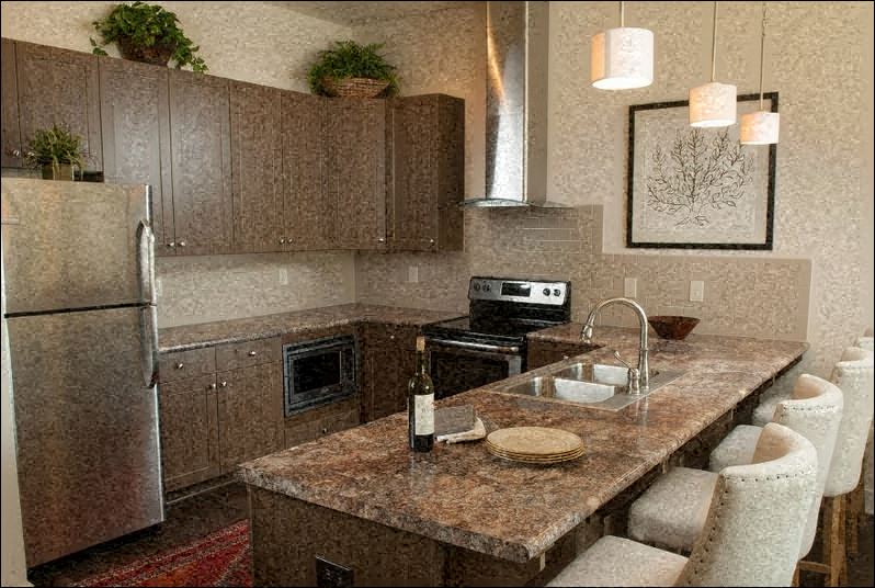 A kitchen with brown cabinets and a granite countertop.