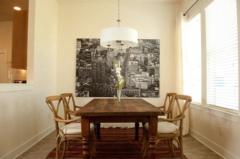 A dining room with a wooden table and chairs.