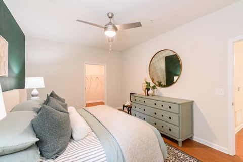 A bedroom with a bed, dresser, and mirror.