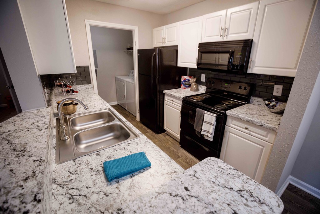 a kitchen with granite counter tops and black appliances