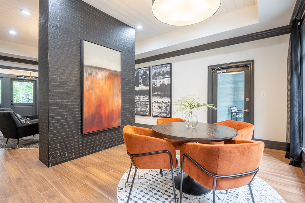 a dining room with orange chairs and a round table
