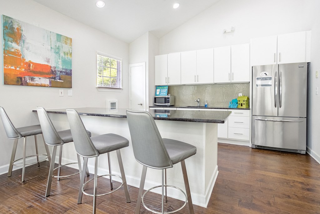 a kitchen with a bar with three stools