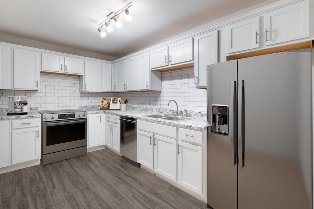 a kitchen with white cabinets and stainless steel appliances