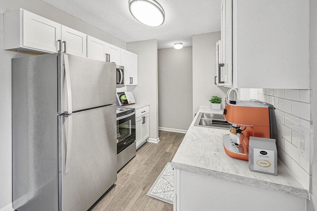 a renovated kitchen with stainless steel appliances and white cabinets