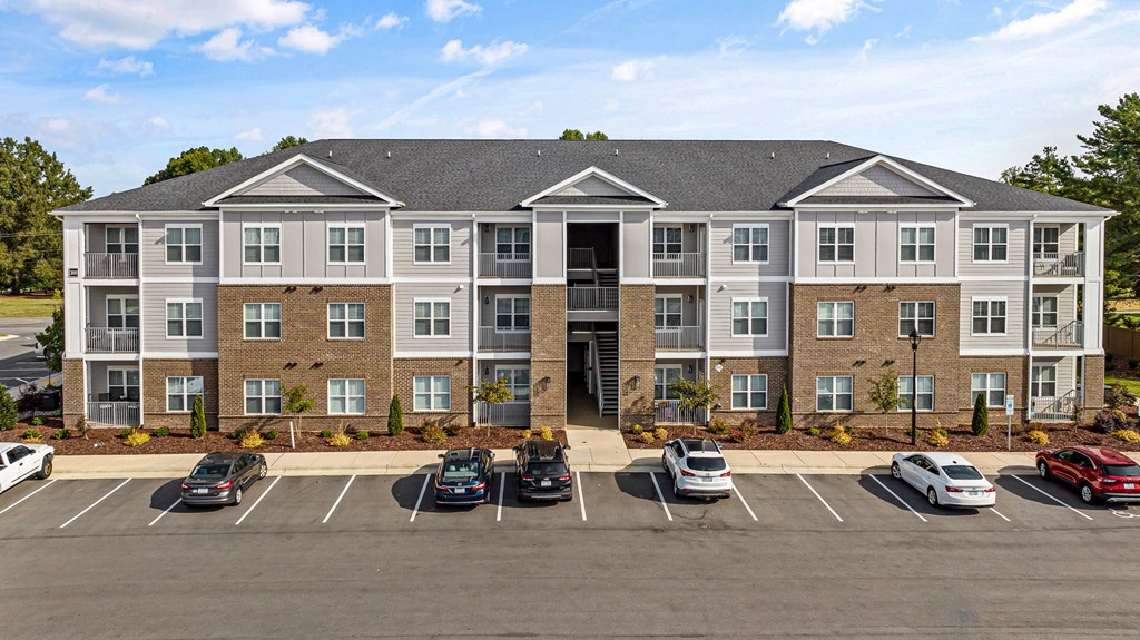 an apartment building in a parking lot with cars