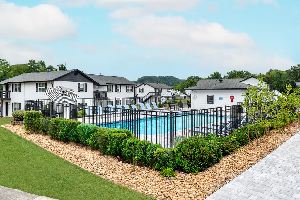 A black and white house with a pool in the backyard.