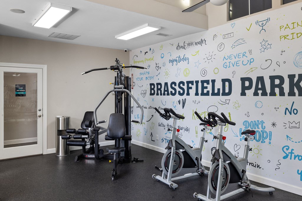 a gym with a white wall with writing on it and exercise equipment