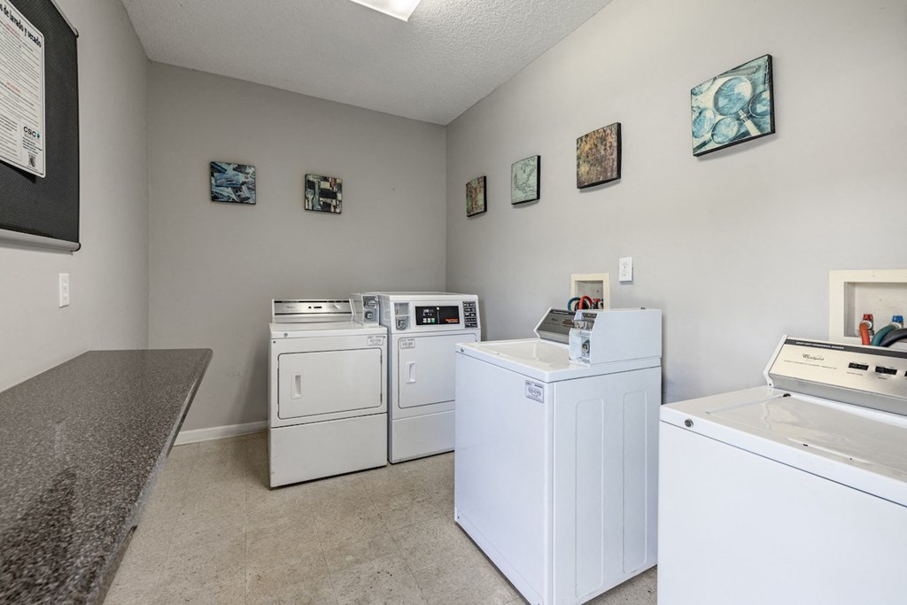 a laundry room with washes and dryers and a counter with a counter top