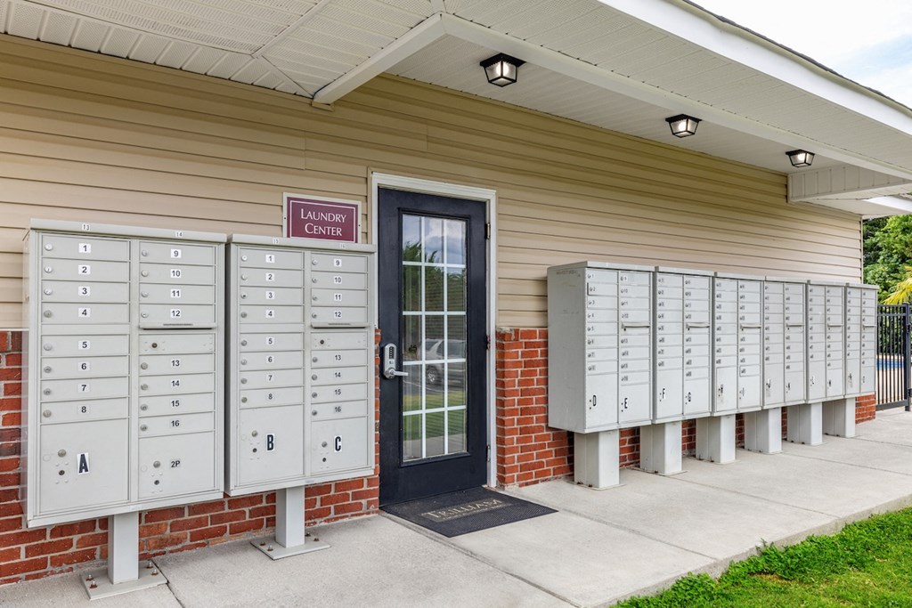 a row of mailboxes outside of a building with a door