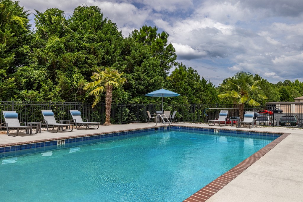 a swimming pool with chairs and umbrellas at the resort
