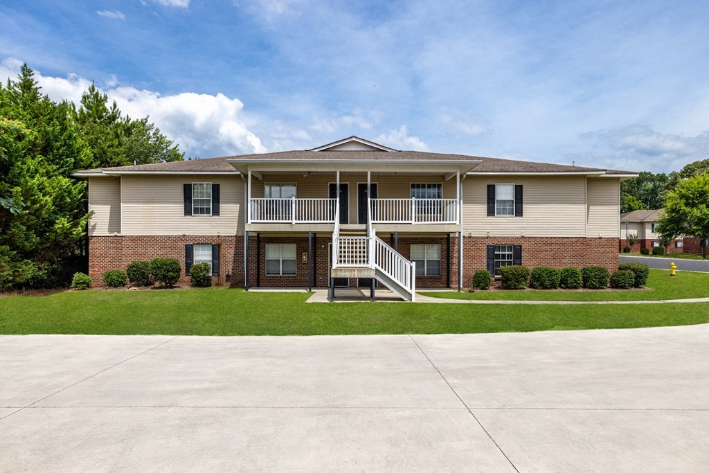 an apartment building with a porch and a staircase
