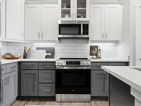 A modern kitchen with a stove top oven and microwave above it.