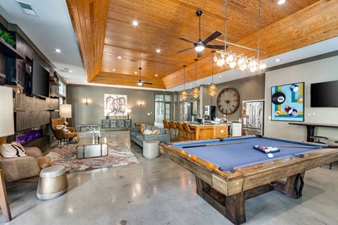 a large living room with a pool table and a tv
