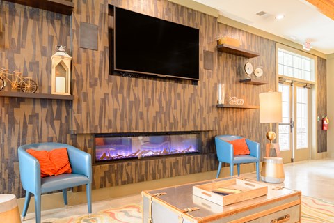 a living room with two blue chairs and a fireplace