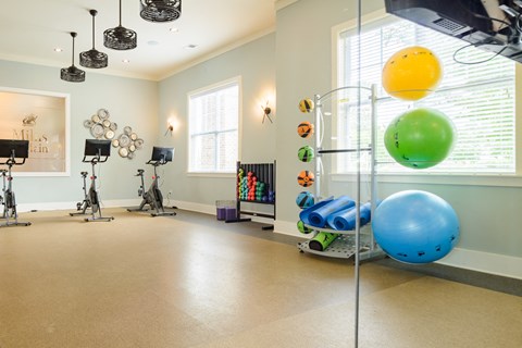 a workout room with weights and balls and a window