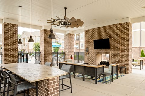 a communal table and seating area with a brick fireplace