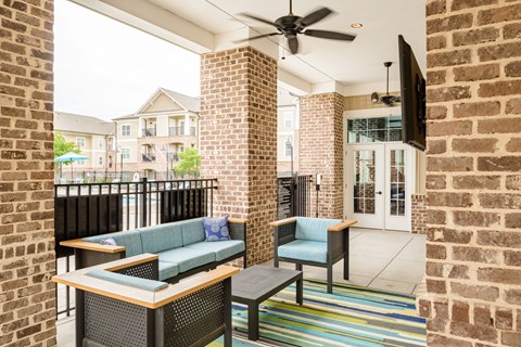a patio with couches and chairs and a ceiling fan