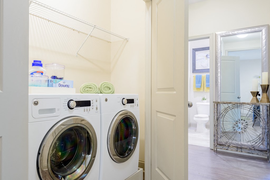 a washer and dryer in a laundry room with a door to the bathroom