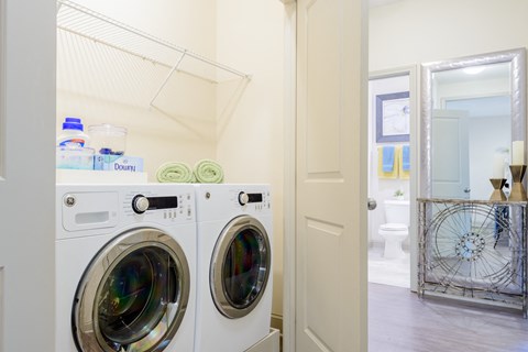 a washer and dryer in a laundry room with a door to the bathroom