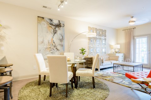a living room and dining room with a table and chairs