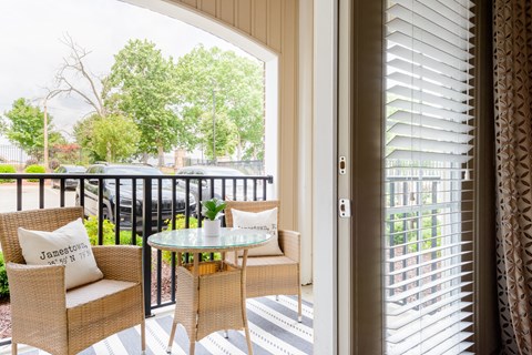 a balcony with two chairs and a table and a door