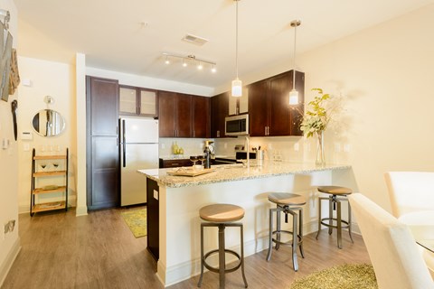 a kitchen with a bar and stools and a refrigerator