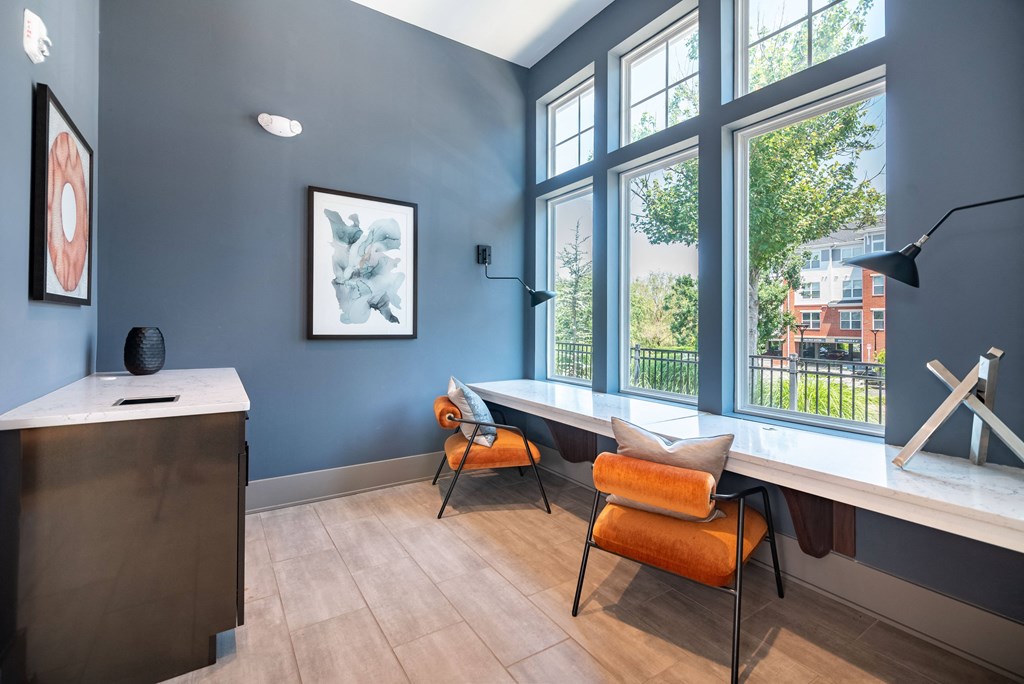 a home office with a desk and chairs and a large window