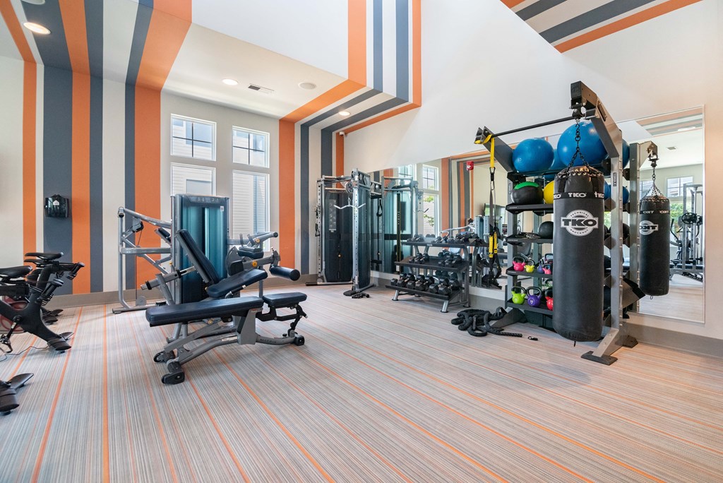 a gym with weights and cardio equipment in a building with striped walls
