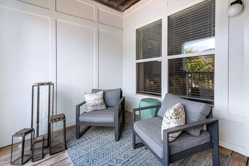 a living room with two chairs and a window