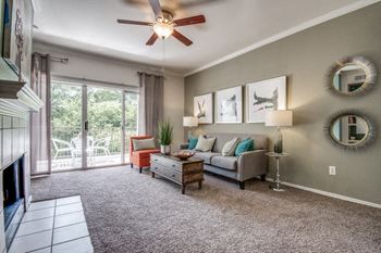 Beautiful living room with plush carpeting, ceiling fan and natural lighting at Hawthorne Riverside