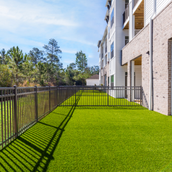 a yard with a fence in front of a building