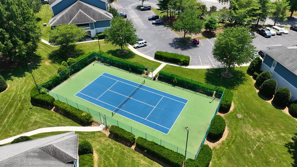 an aerial view of a tennis court in a parking lot
