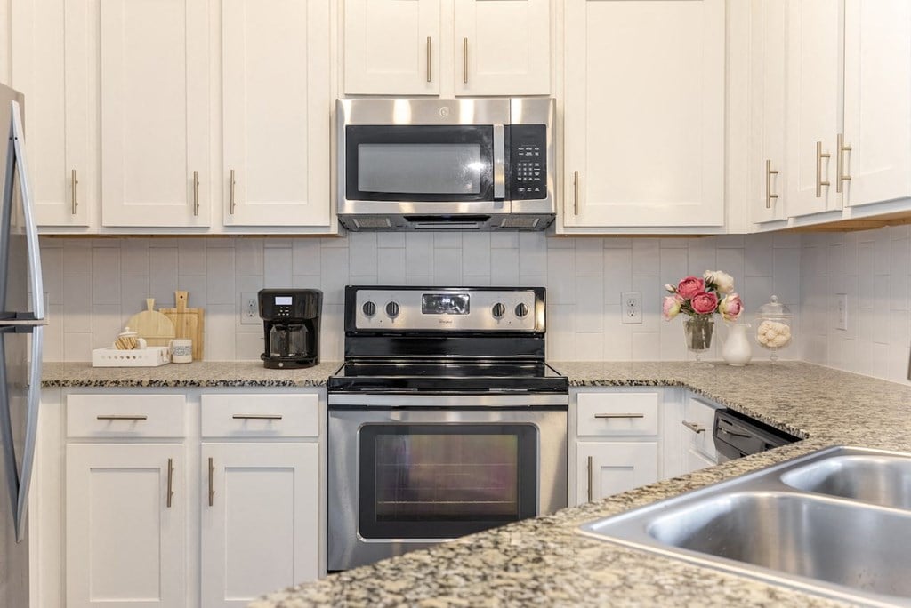 a kitchen with white cabinets and stainless steel appliances