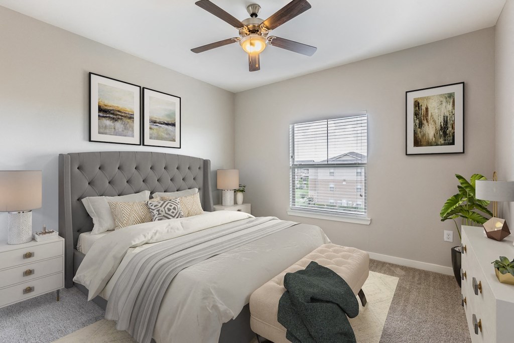 an empty bedroom with a bed and a ceiling fan