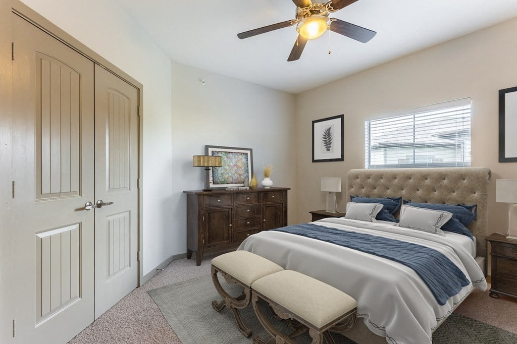 a bedroom with a bed and a ceiling fan