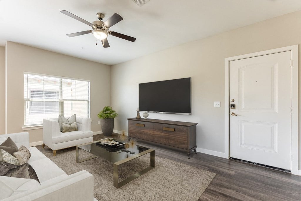 a living room with a ceiling fan and a television