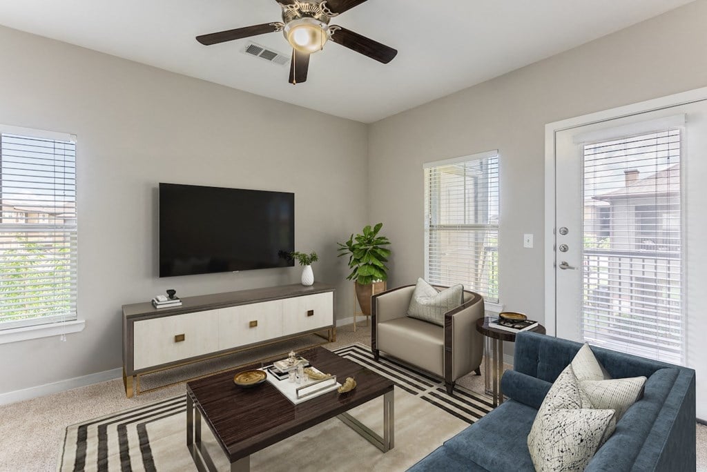 a living room with a ceiling fan and a television