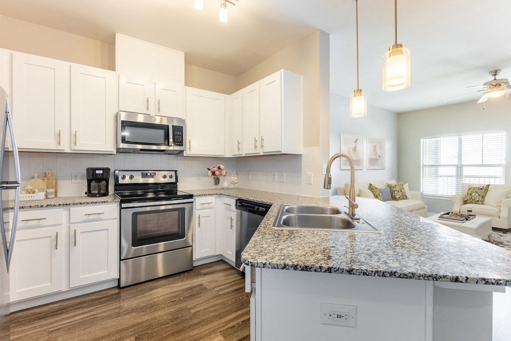 a kitchen with white cabinets and granite counter tops